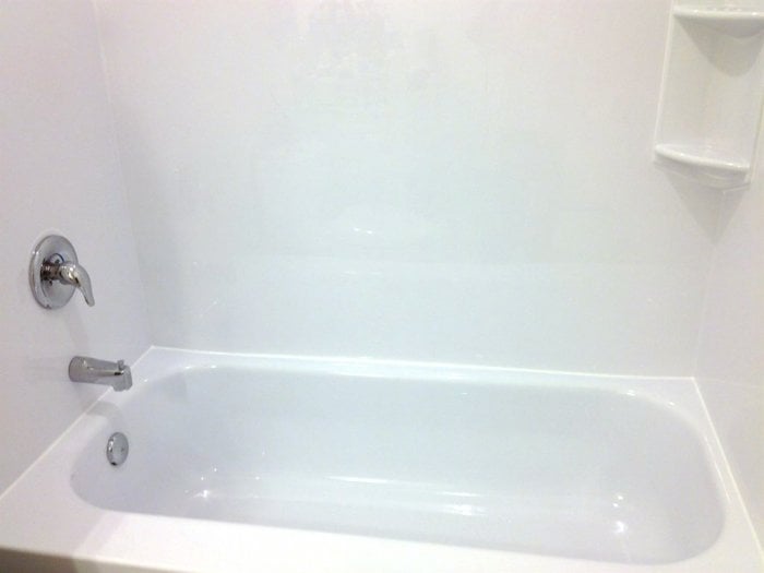 Newly installed custom tub liner with corner storage and Moen fixtures